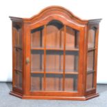 A modern walnut wall mounted display cabinet, arched top, glazed doors encl