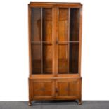 An oak glazed bookcase, three-quarter height glazed panelled doors enclosin