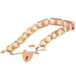 A rose metal bar link bracelet with padlock fastener, three oval rings to c