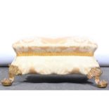 An upholstered footstool, on cast brass lion paw feet, gold brocade upholst