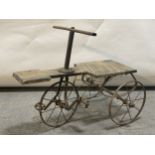 A Victorian tricycle, shaped wooden seat supported on cast metal frame and