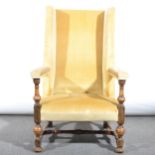 A wing-back easy chair, in the 17th Century style, turned oak frame, width