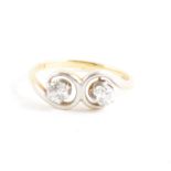 A diamond two stone ring, the old brilliant cut stones claw set in a yellow