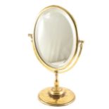 A brass dressing table mirror, oval bevelled plate, 49cm.