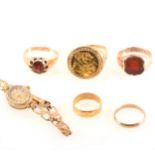 Five gold rings and a wrist watch, a 9 carat yellow gold mount set with a r