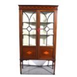 An Edwardian inlaid mahogany display cabinet, the frieze inlaid with ribbon