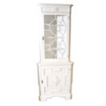 A painted freestanding corner cupboard, glazed door to the upper section, t