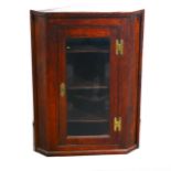 An oak wall mounted corner cupboard with glazed door, depth 49cm, height 95