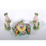 Pair of Continental porcelain figures of putti, encrusted floral decoration