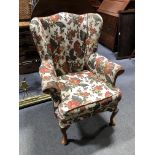 A wing-back easy chair, loose cushions, on cabriole legs, width 75cm.