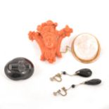 A carved coral brooch, cameo brooch and jet brooch.