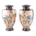 A pair of Japanese Satsuma shouldered vases decorated with two panels of colourful figures in a