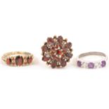 Two garnet dress rings and an amethyst ring.