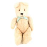 A white wool plush teddy bear, c1930, straw filled, 42cm tall.