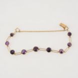 A yellow metal bracelet individually claw set with nine amethysts,