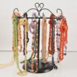 A collection of tumblestone necklaces on a stand.