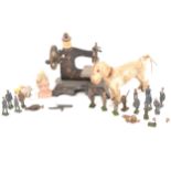 A child's hand crank toy sewing machine, lead figures, dog on wheels, three dolls heads.