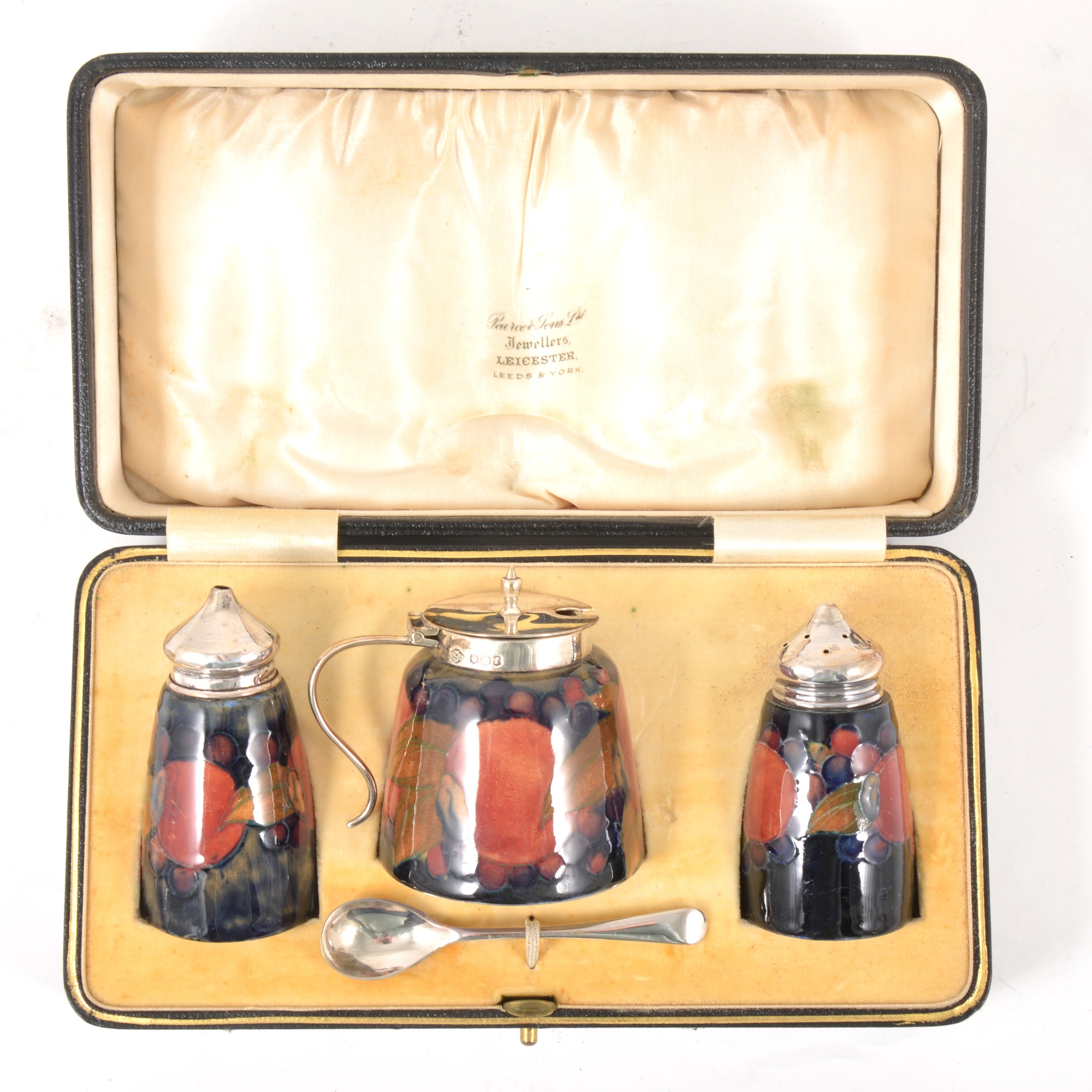 A three-piece silver-mounted William Moorcroft 'Pomegranate' pattern cruet