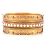 A Victorian yellow metal half hinged bangle set with pearls.