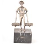 A white metal model of a fisherman on a marble base.