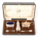 A three-piece condiments set, Walker & Hall, Birmingham 1932, plus two silver salt spoons.