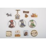 A Scottie dog lipstick holder and ten Scottie brooches with metal detail.