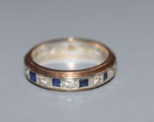 A 9ct yellow and white metal, two colour sapphire eternity ring, size L.