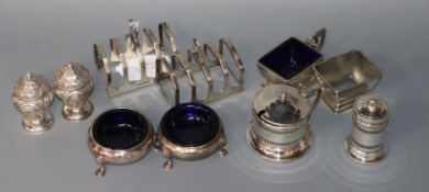 A pair of George V silver toast racks, Sheffield, 1934 and seven assorted silver condiments
