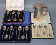 Three cased sets of silver teaspoons and a silver hot water pot.