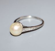 A white metal (stamped 'Plat') and cultured pearl dress ring with diamond set shoulders, size O/P.