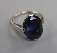 A white metal and oval synthetic? sapphire dress ring, size L.