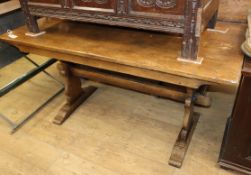 An 18th century style oak trestle dining table on shaped end supports Length 152cm