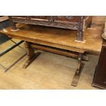 An 18th century style oak trestle dining table on shaped end supports Length 152cm