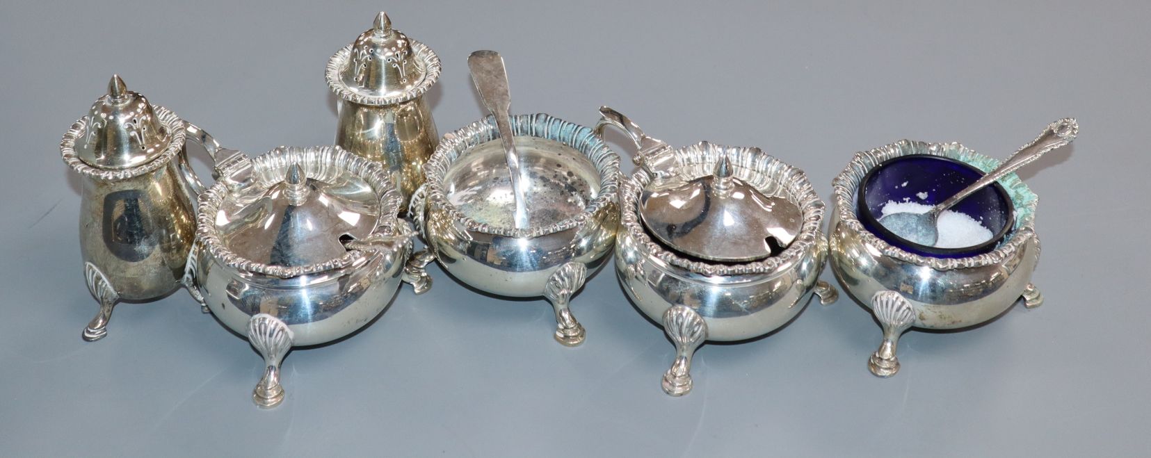 A George VI silver six piece condiment set by Mappin & Webb, with three silver condiment spoons.