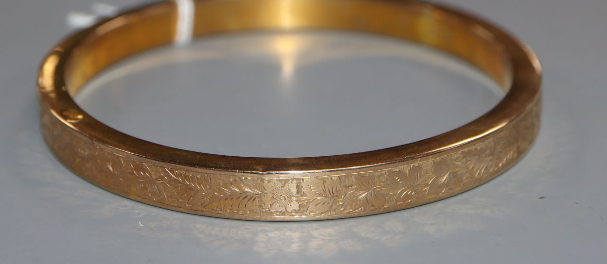 An engraved 9ct. gold bangle, interior diameter 82mm, 19.6 grams.