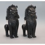 A pair of Thai bronze lion dogs height 27cm approx.