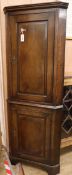 An 18th century panelled oak two-door standing corner cupboard H.188cm