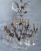 An Italian bronze and cut glass twelve light chandelier, hung with flower and lappet and tear shaped