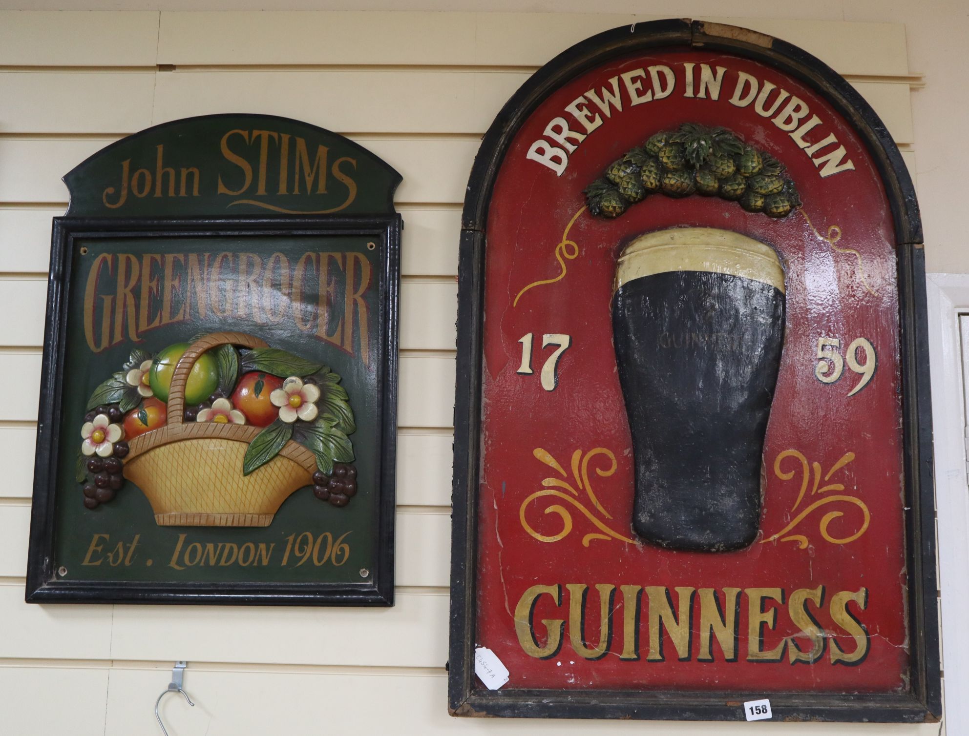 A Guinness sign and a John Stims Greengrocer sign