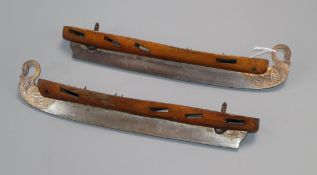 A pair of Russian gilded steel and walnut ice skate blades