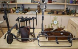 A wrought iron spit, an oak whip rack and a pair of andirons and a leather jug