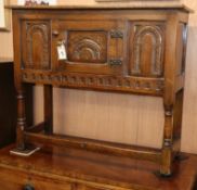 A reproduction carved oak small low cupboard W.92cm