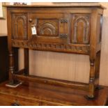 A reproduction carved oak small low cupboard W.92cm