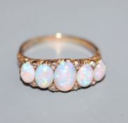 An early 20th century 18ct. gold, graduated five stone white opal and diamond chip half hoop ring,