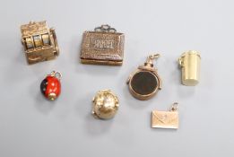 Seven assorted charms, including a 9ct gold fruit machine, a 9ct gold and bloodstone spinning fob,