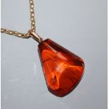 An amber pebble pendant, on a 9ct chain, pendant 34mm.