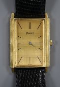 An 18ct gold Piaget rectangular dial manual wind wrist watch, on associated leather strap.