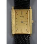 An 18ct gold Piaget rectangular dial manual wind wrist watch, on associated leather strap.