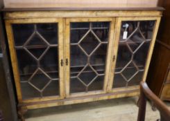 A figured walnut bookcase fitted three astragal-glazed doors W.138cm
