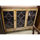 A figured walnut bookcase fitted three astragal-glazed doors W.138cm